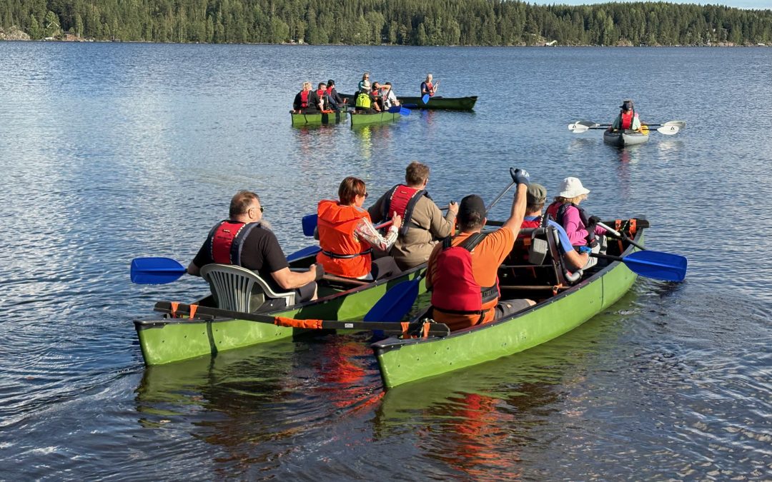 Ihmisiä melomassa kajaakeilla järvellä