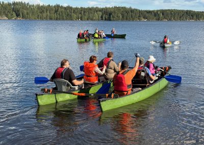 Ihmisiä melomassa kajaakeilla järvellä