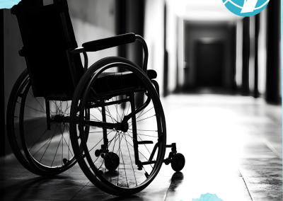 Mustavalkoinen kuva, jossa pyörätuoli on tyhjällä käytävällä