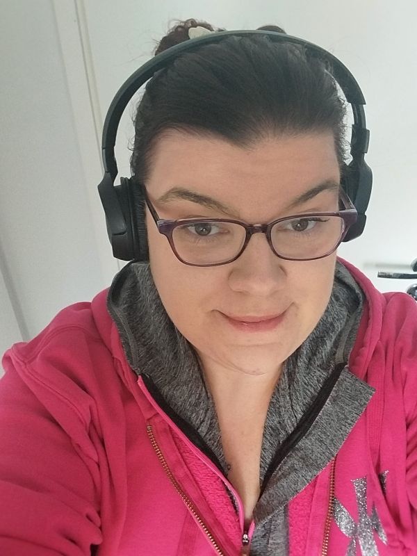 Sonjalla on kuvassa sporttinen pinkki takki, kuulokkeet ja silmälasit.